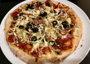 Pizza carpicciosa met tomatensaus, ham, artisjokken, champignons, olijven en kaas.foto © LekkerAntwerpen.be 2024